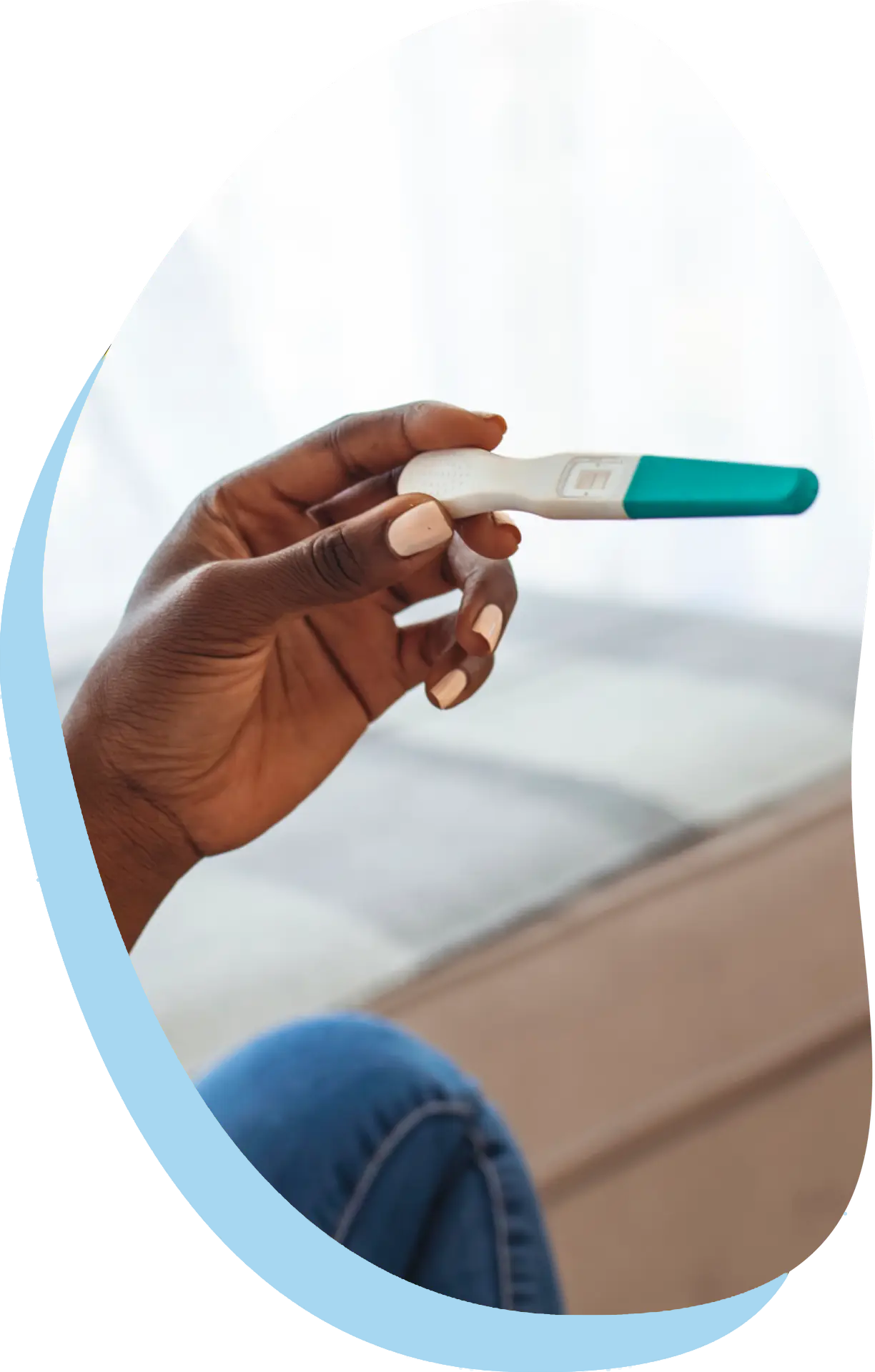 Hand holding a device showing results from a pregnancy test at First Care Women’s Health.