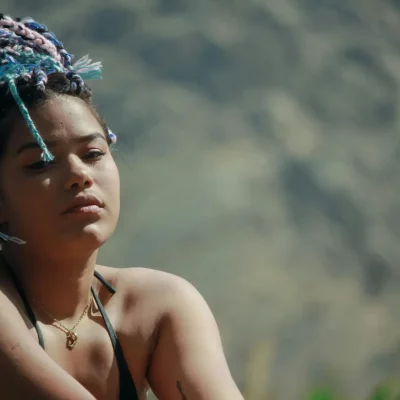 Thoughtful woman outdoors, braided hair.