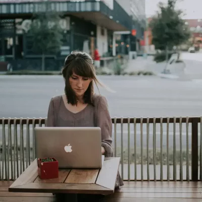 Woman working on laptop at café.