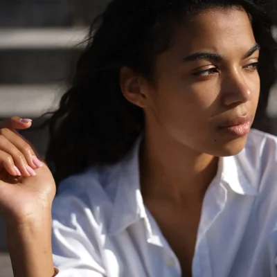 Thoughtful woman in sunlight outdoors