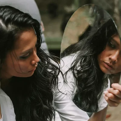 Woman looking at her reflection in mirror